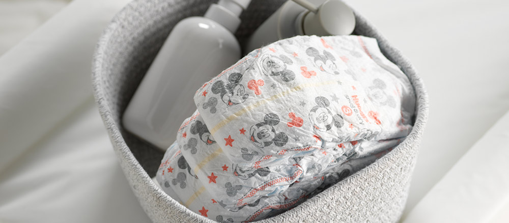 A gray tote full of Huggies Snug and Dry Diapers with Mickey Mouse designs