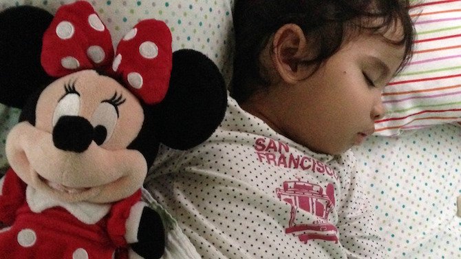 Baby sleeping with minnie mouse doll