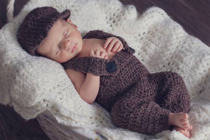 Sleeping baby in brown wool overall outfit