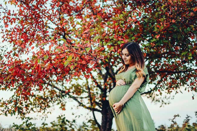 Pregnant woman outside on a fall day