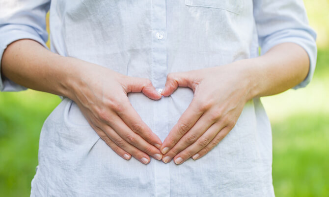 Mother holding hands in shape of heart over her belly