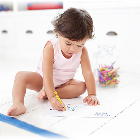 Toddler coloring in a disney activity book