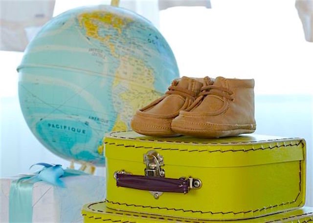 baby shoes with a suitcase and globe