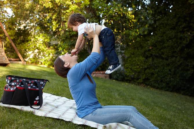 mom holding baby in the air giggling