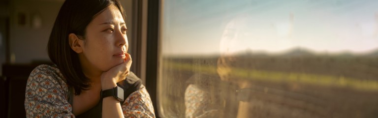 young woman looking wistfully out a window