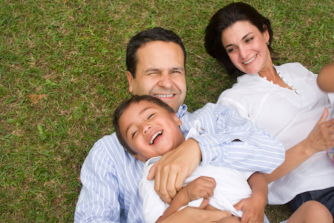 Mom, dad, and son lying in grass enjoying each other