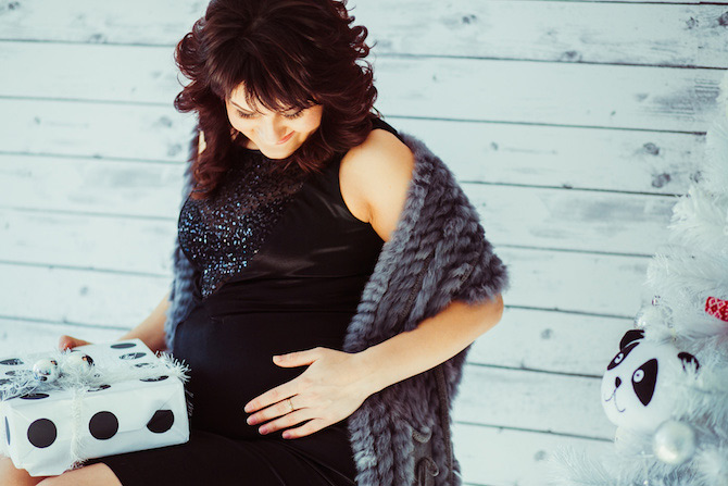 Pregnant woman dressed up holding a gift