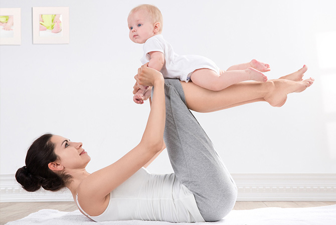 Mom performing yoga with baby in her lap